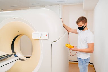 Mühendis elektrik cihazındaki voltajı ölçer..