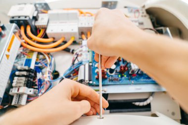 Tornavidayla mühendisin eli, onarımdan sonra tıbbi ekipmanları birleştirir.