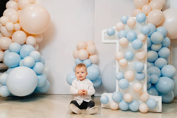 little boy in front of photo zone with balloons