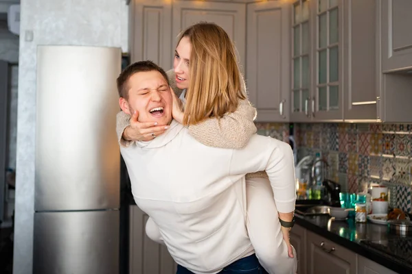 Счастливая и любящая пара валяет дурака и обнимается дома на кухне — стоковое фото