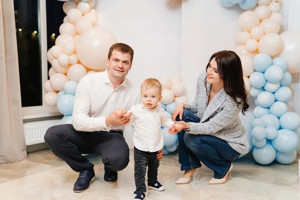 Heureux papa, maman et fils devant la zone photo avec des ballons — Photo