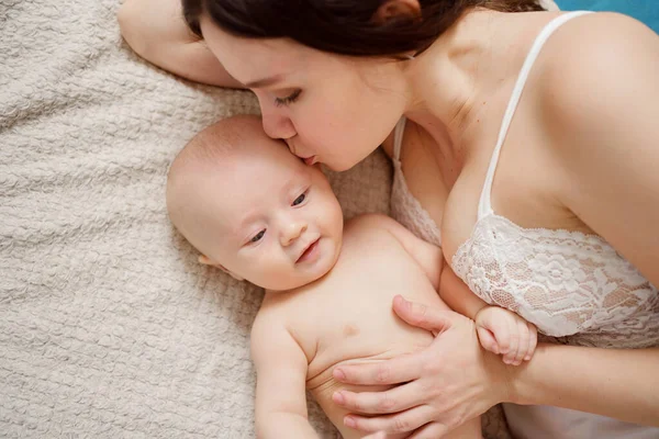 Una madre y el bebé en la cama. salud materna e infantil. — Foto de Stock