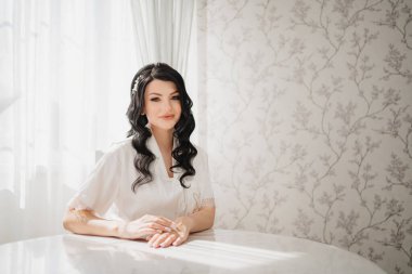 Masada beyaz ipek pijamalı esmer gelin.