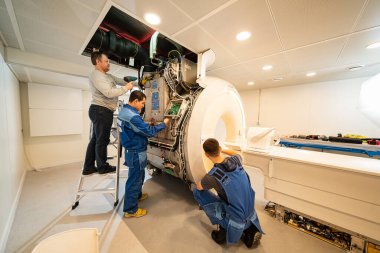 engineers of the magnetic resonance imaging apparatus configure the scanner. clipart