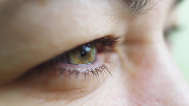 Крупним планом. Відкривається зелене око жінки. офтальмологія — стокове відео