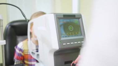 Yarık lambalı çocuğun muayenesi. göz doktoru, bir optik mağazası..