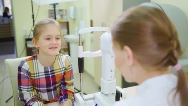 Doktor rozhovory holčička před vyšetřením v oftalmologové kancelář. — Stock video