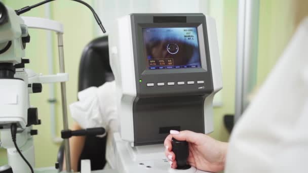 Läkare undersöker childs öga på skärmen av autorefractometer. oftalmisk anordning. — Stockvideo