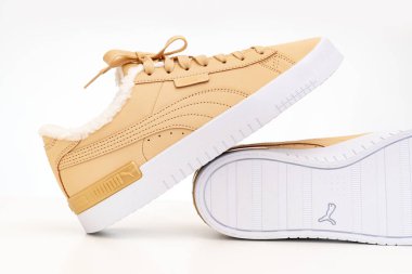 Açık kahverengi kış ayakkabıları Puma beyaz arka planda beyaz tabanlı kürklü..