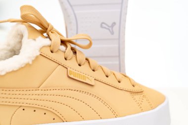 Açık kahverengi kış ayakkabıları Puma beyaz arka planda beyaz tabanlı kürklü..