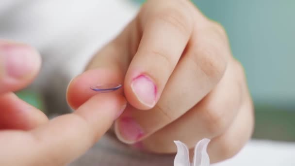 Nahaufnahme. auf Kontaktlinse am Finger eines Kindes Tropfen Augentropfen. — Stockvideo