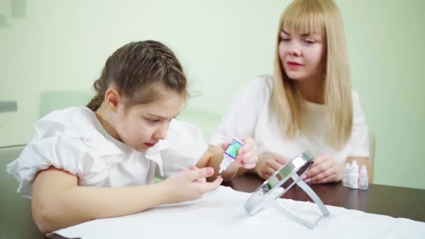 Läkare lär flickan att bära kontaktlinser på kliniken. ortokeratologiska linser — Stockvideo