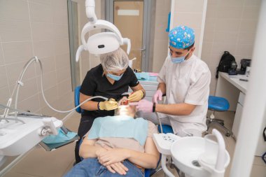 Dişçi hastaların dişlerini fırçalar. düzenli bakım ve önleme.