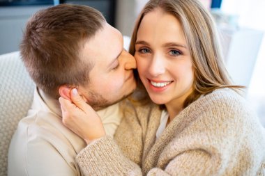 Mutlu ve sevgi dolu bir çift evde, kanepede.