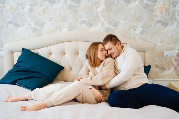 A happy and loving couple hugs on the bed — Stock Photo, Image
