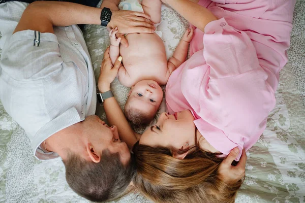 Los padres se acuestan con el bebé. la felicidad de la maternidad. —  Fotos de Stock