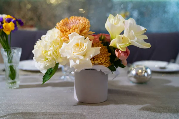 Hermoso ramo de flores de colores en una caja de sombreros en la mesa de comedor. — Foto de Stock