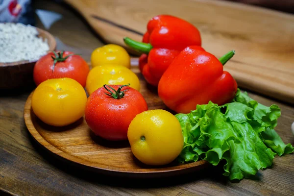 Lechuga, tomates amarillos y rojos y pimiento con gotas de agua. pepinos. — Foto de Stock