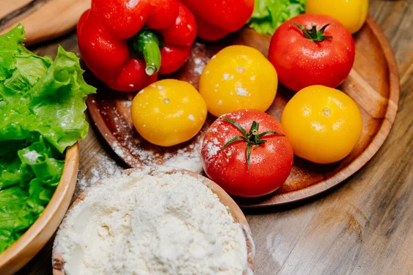 Uma tigela de madeira de farinha e legumes na mesa da cozinha. produtos agrícolas — Fotografia de Stock