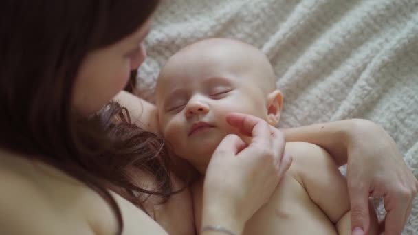 A beautiful naked baby sleeps in his mothers arms. the happiness of motherhood. — Stock Video