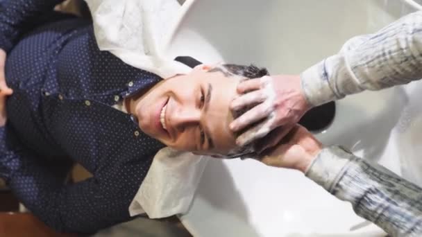 한 미용사 가 이발소에서 갈색 머리를 씻고 있는 모습. — 비디오