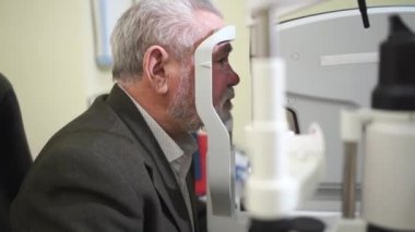 Korneo topoğrafyasındaki yaşlı adamın muayenesi. Modern klinik.
