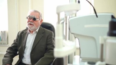 Göz doktoru yaşlıların görüşünü teşhis ediyor ve lens seçiyor.. 