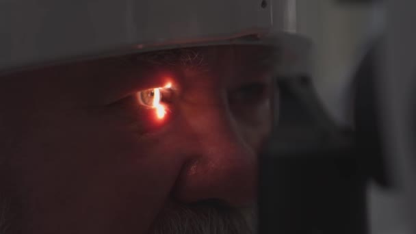 Untersuchung eines älteren Mannes mit Spaltlampe. Ausstattung der Augenarztpraxis. — Stockvideo