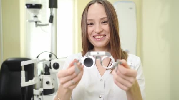 Ophtalmologiste avec cadre d'essai pour la sélection des lunettes, examen — Video