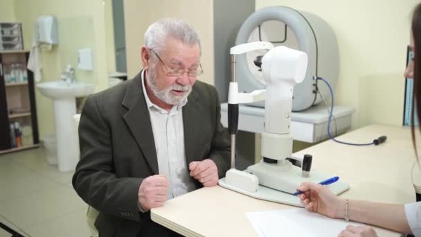 Médico entrevista al anciano antes de ser examinado en el consultorio de oftalmólogos. — Vídeos de Stock