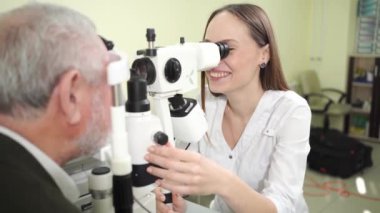 Kesik lambalı yaşlı adamı göz doktoru muayenesi. tıbbi ekipman