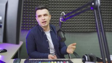 Erkek bir radyo sunucusu profesyonel bir radyo stüdyosunda canlı yayın yapıyor.. 