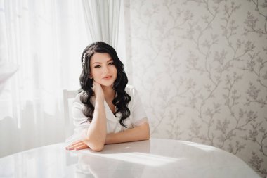 Masada beyaz ipek pijamalı esmer gelin.