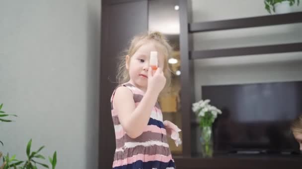 Маленька дівчинка з рукавичкою з однієї руки і пляшкою з іншої. експерименти . — стокове відео