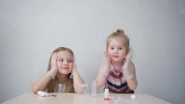 Koruyucu eldivenli şirin küçük kızlar evde yapılacak deneylere hazırlanıyorlar. — Stok video