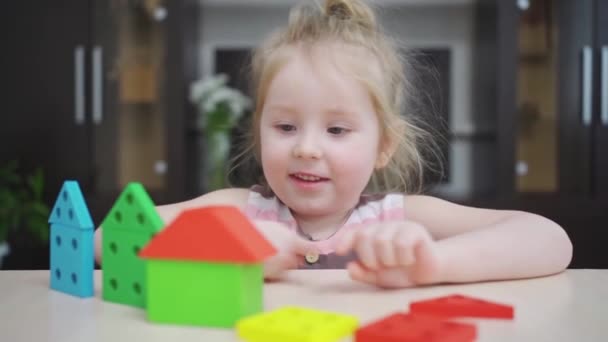 可愛い女の子がカラフルな木造建築の家を建て. — ストック動画