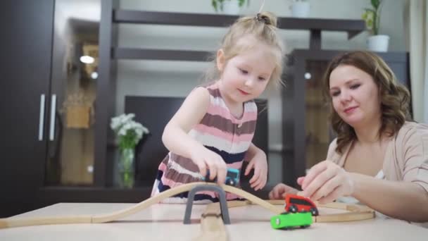 Mama i córka bawią się drewnianą koleją zabawek. — Wideo stockowe
