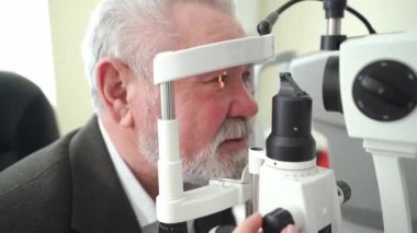 Kesik lambalı yaşlı adamı muayene etmek. oftalmologların ofisi.