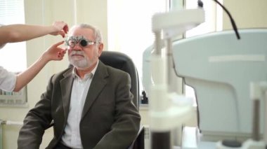 Göz doktoru yaşlıların görüşünü teşhis ediyor ve lens seçiyor.. 