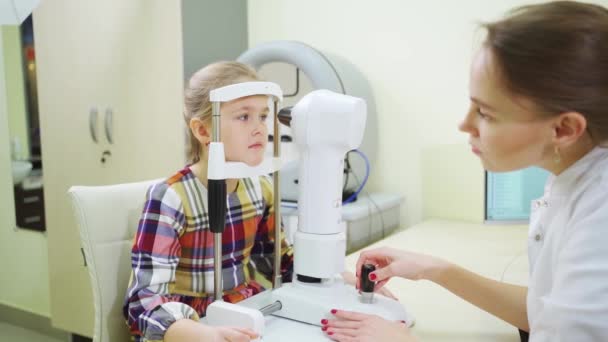 Ophtalmologiste examine la fille sur un topographe cornéen. clinique moderne. — Video
