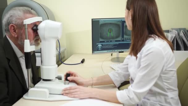 Examen oftalmólogo del anciano en la clínica corneo topographer.modern — Vídeos de Stock