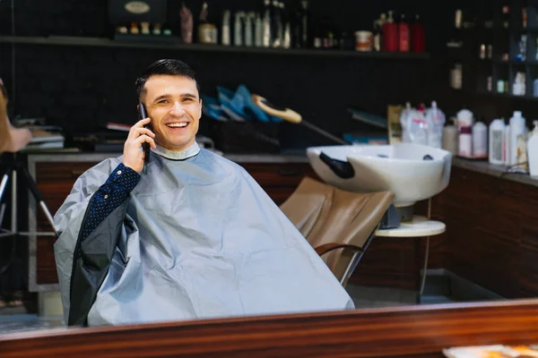 Facet rozmawia przez telefon u fryzjera. męska fryzura i pielęgnacja włosów. — Zdjęcie stockowe
