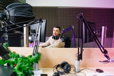 Bir spor spikeri radyo stüdyosunda canlı yayın yapmaya hazırlanıyor..