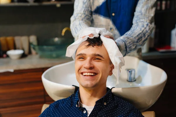 Fryzjer chusteczki włosy brunetka człowiek z jednorazowym ręcznikiem po umyciu włosów — Zdjęcie stockowe