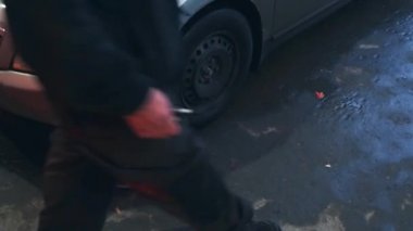 Eski arabanın tekerleğinin yerine takılan lastik gri renktedir. Tamirci direksiyonu çeviriyor.