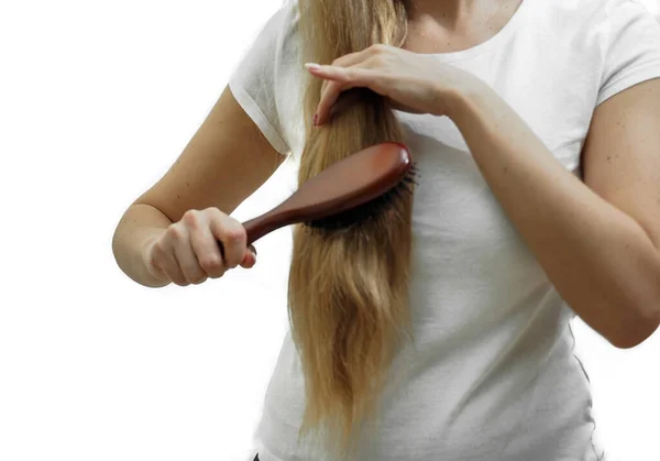Uzun sarı saçlı bir kız onları tarak ile tarıyor. Saç dökülmesi, saç dökülmesi, saç bakımı sorunu. — Stok fotoğraf