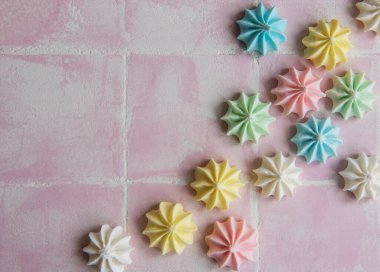 Pembe arka planda küçük renkli kremalar