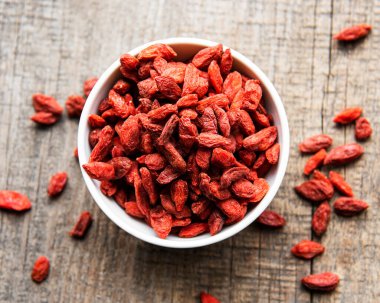 Sağlıklı beslenmek için kuru kırmızı goji üzümleri eski ahşap arka planda.