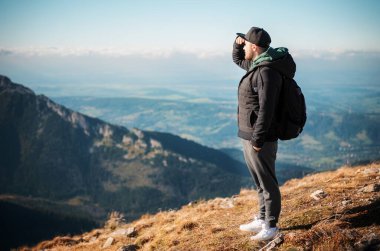 Yakışıklı genç adam güneşli bir günde dağların önüne bakıyor. Kasprowy Wierch. Polonya. 