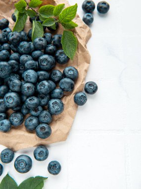 Beyaz fayans zemininde taze toplanmış yaban mersini. Sağlıklı beslenme kavramı